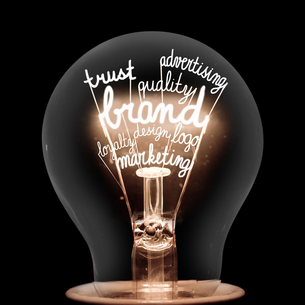 Single light bulb with shining fibers in a shape of Brand, Identity, Value, Marketing and Trust concept related words isolated on black background.